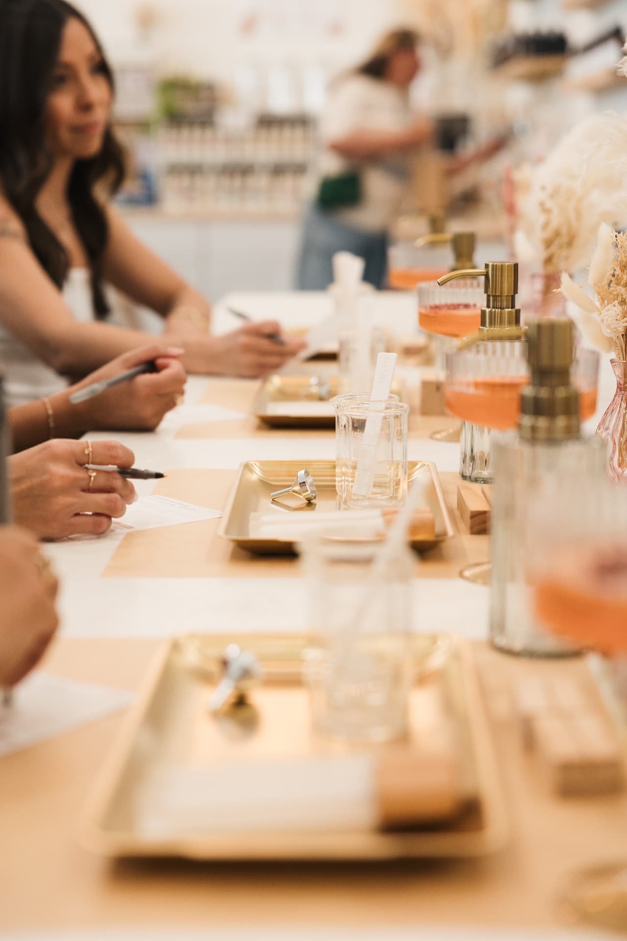 Guests at the blending table with gold trays, beakers and testing strips